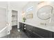 Bright bathroom with dual vanities, stylish mirrors, and a glass-enclosed shower leading to a closet at 135 Grant Dr, Sarasota, FL 34236