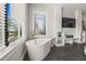 Elegant bathroom with a freestanding tub, large window, and decorative shelving at 135 Grant Dr, Sarasota, FL 34236