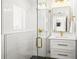 Modern bathroom featuring a glass shower with gold fixtures, a white vanity, and ample natural light at 135 Grant Dr, Sarasota, FL 34236