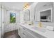 Elegant bathroom featuring a marble shower, white vanity with dual sinks, and modern gold fixtures for a spa-like feel at 135 Grant Dr, Sarasota, FL 34236
