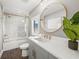 Modern bathroom features a glass shower door, large round mirror, and gray vanity at 135 Grant Dr, Sarasota, FL 34236