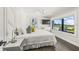 Bright bedroom with a large window view, ceiling fan, wall-mounted TV, and stylish decor at 135 Grant Dr, Sarasota, FL 34236