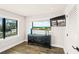 Cozy room with wood floors, a black cabinet, large windows offering a serene outdoor view, and a wall-mounted TV at 135 Grant Dr, Sarasota, FL 34236