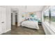 Bright bedroom with wood floors, white walls, a ceiling fan, and a large window showcasing outdoor views at 135 Grant Dr, Sarasota, FL 34236