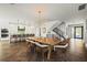 Open-concept living space with modern dining table, kitchen island with bar seating, and staircase at 135 Grant Dr, Sarasota, FL 34236