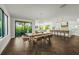 Bright dining area featuring a wooden table, unique chandelier, and large sliding doors leading to a patio at 135 Grant Dr, Sarasota, FL 34236