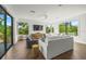 Bright living room with plush white sofa, sleek furniture, and large windows offering views of tropical greenery at 135 Grant Dr, Sarasota, FL 34236