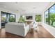 Open-concept living area with large windows, comfortable seating, and stylish decor with views of lush greenery at 135 Grant Dr, Sarasota, FL 34236