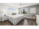 Sunlit bedroom with a white bed, ceiling fan, and a large window offering neighborhood views at 135 Grant Dr, Sarasota, FL 34236
