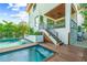 Backyard pool and spa featuring fountains, wood deck, and staircase to upper level patio at 135 Grant Dr, Sarasota, FL 34236