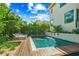 Backyard pool with fountains, lush landscaping, and lounge chairs on a wood deck at 135 Grant Dr, Sarasota, FL 34236