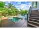 Lovely pool and spa area with wood decking, stairs, and lush tropical landscaping at 135 Grant Dr, Sarasota, FL 34236