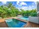 Inviting backyard pool area with lush tropical landscaping and wood decking at 135 Grant Dr, Sarasota, FL 34236