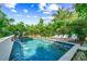 Inviting backyard pool area with fountains, lush tropical landscaping, and lounge chairs at 135 Grant Dr, Sarasota, FL 34236