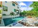 Beautiful outdoor pool area with spa, fountains, lounge chairs, and lush landscaping at 135 Grant Dr, Sarasota, FL 34236