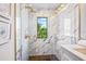 Luxurious shower with marble-like tiles, a window view, and stylish gold fixtures, providing a spa-like experience at 135 Grant Dr, Sarasota, FL 34236