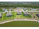 Aerial view of homes with manicured lawns, and a lake and wooded area in the distance at 14914 15Th E St, Parrish, FL 34219