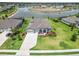 Aerial view of a home with lush landscaping, a well-manicured lawn, and a tranquil lake in the background at 14914 15Th E St, Parrish, FL 34219