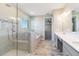 Bright bathroom with a glass shower, soaking tub, double vanity, tile surround and wood-look flooring at 14914 15Th E St, Parrish, FL 34219