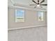 Spacious bedroom with plush gray carpet, two windows, and a ceiling fan at 14914 15Th E St, Parrish, FL 34219