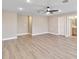Spacious bedroom with neutral walls, ceiling fan, and light wood-look floors leads to bath at 14914 15Th E St, Parrish, FL 34219
