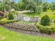 Stone entrance sign for Twin Rivers community is surrounded by colorful flower beds and greenery at 14914 15Th E St, Parrish, FL 34219