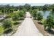 Long driveway leading to a gated entrance, surrounded by mature trees and a pond at 14914 15Th E St, Parrish, FL 34219