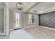 Bright foyer with a decorative front door, elegant chandelier, tray ceiling, and light wood-look floors at 14914 15Th E St, Parrish, FL 34219