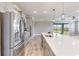Modern kitchen with stainless steel appliances, an island with seating, and wood-look tile flooring at 14914 15Th E St, Parrish, FL 34219