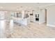 Open kitchen with white cabinets, stainless steel appliances, a large island with seating, and wood-look tile flooring at 14914 15Th E St, Parrish, FL 34219