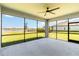Screened lanai with a ceiling fan, a view of the lawn and lake, and a concrete floor at 14914 15Th E St, Parrish, FL 34219