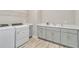 Bright laundry room featuring a washer, dryer, sink, and gray cabinets at 14914 15Th E St, Parrish, FL 34219