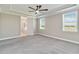 Spacious main bedroom with tray ceiling, fan, and en-suite bathroom entrance at 14914 15Th E St, Parrish, FL 34219