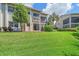 Spacious backyard with lush green grass, landscaping, and outdoor deck at 1612 Starling Dr # 101, Sarasota, FL 34231