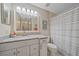 Well-lit bathroom with granite countertop, gray-striped shower curtain, and modern sink at 1612 Starling Dr # 101, Sarasota, FL 34231