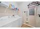 Functional laundry room with washer, dryer, and storage shelves at 1612 Starling Dr # 101, Sarasota, FL 34231