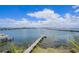 Beautiful aerial shot showing a dock extending into the water with clear sky and a distant bridge at 201 Bay N Dr, Bradenton Beach, FL 34217