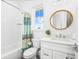 Clean bathroom with bright white vanity, shower/tub, and round decorative mirror at 201 Bay N Dr, Bradenton Beach, FL 34217