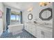 Elegant bathroom with blue tile flooring, soaking tub, dual sinks, and beautiful water views at 201 Bay N Dr, Bradenton Beach, FL 34217
