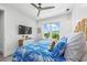 Bright bedroom features a ceiling fan, large window, and tropical themed bedding and decor at 201 Bay N Dr, Bradenton Beach, FL 34217