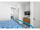 Cozy bedroom featuring TV, ensuite bath, wooden floors, and bright, neutral walls at 201 Bay N Dr, Bradenton Beach, FL 34217