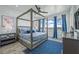 Serene bedroom featuring a four-poster bed, blue accents, and scenic water views from large windows at 201 Bay N Dr, Bradenton Beach, FL 34217