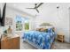 Comfortable bedroom with a tropical bedspread, shiplap wall, and a ceiling fan at 201 Bay N Dr, Bradenton Beach, FL 34217