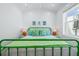 Bright bedroom with vibrant green accents, shiplap wall, and a window bringing in natural light at 201 Bay N Dr, Bradenton Beach, FL 34217