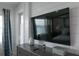 Cozy bedroom features a large flat-screen television, shiplap wall detail, and calming blue curtains at 201 Bay N Dr, Bradenton Beach, FL 34217