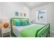 Bright bedroom featuring vibrant green bedding, decorative pillows, and side table lamps at 201 Bay N Dr, Bradenton Beach, FL 34217