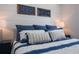 Bedroom featuring a luxurious blue and white bedding set with decorative pillows and matching wall art at 201 Bay N Dr, Bradenton Beach, FL 34217