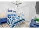 Bright bedroom with ceiling fan, modern décor, and vibrant blue and white bedding at 201 Bay N Dr, Bradenton Beach, FL 34217