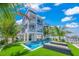 Stunning exterior view of a multi-story waterfront home with a pool and beautiful landscaping at 201 Bay N Dr, Bradenton Beach, FL 34217