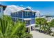 Exterior view of a raised waterfront home with lush tropical landscaping and a metal roof at 201 Bay N Dr, Bradenton Beach, FL 34217